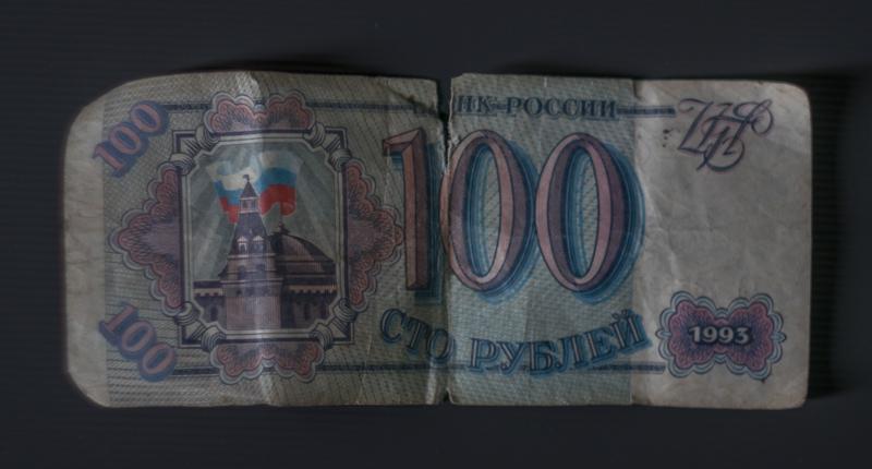 100 Venäjän ruplaa etupuolelta kuvattuna. Tausta on tummansininen tai -harmaa.
