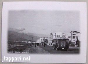 Ruskeasävyinen, vanha valokuva bussista ja maantiestä.